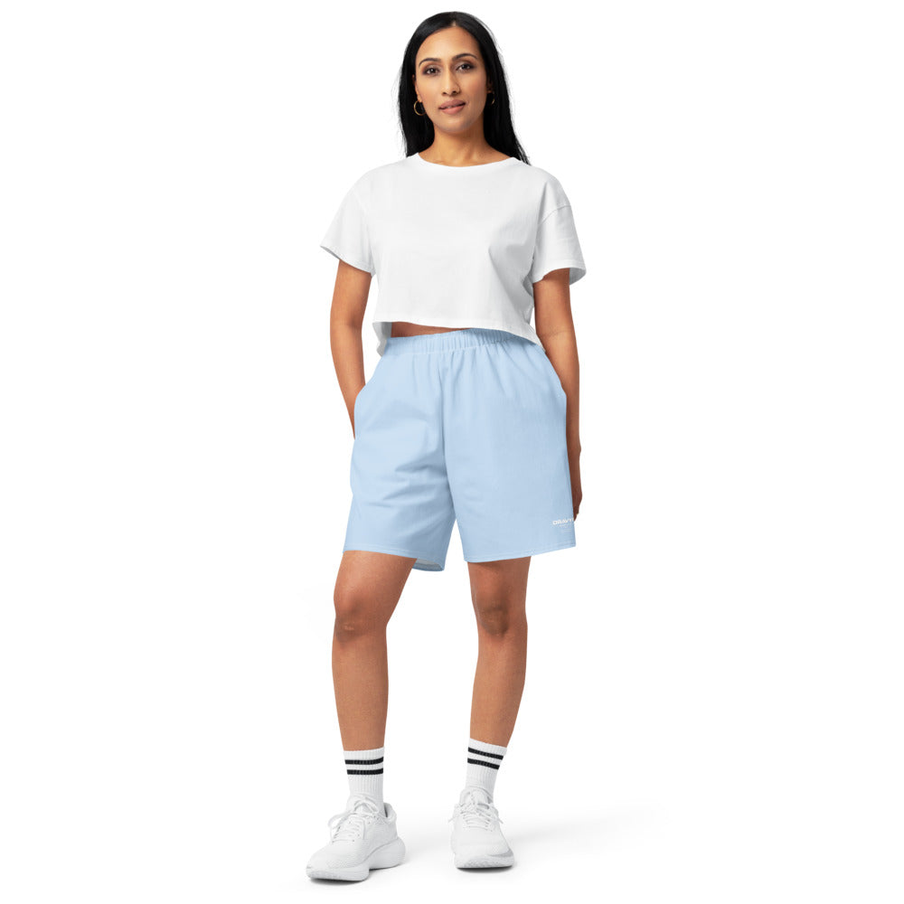 Model in a relaxed fit wearing DRAVYN Cotton long short with a cropped t-shirt and white sneakers.